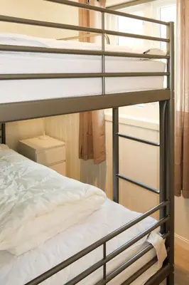 a bedroom with a bunk bed with white sheets at Holiday Home Nesholmen by Interhome in Leirvik