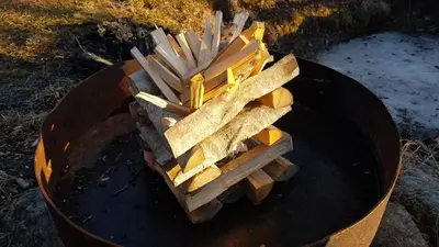 a pile of wood sitting on top of a grill at Ønskedrømmen hytteutleie in Brandbu