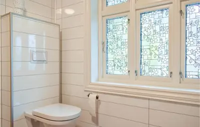 a bathroom with a toilet and a stained glass window at Solvang in Hebnes