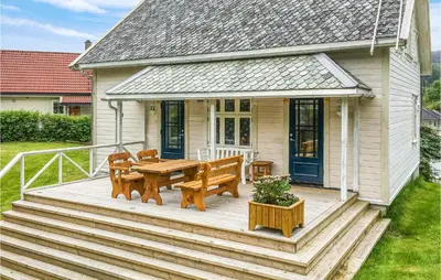 a wooden deck with a table and benches on a house at Solvang in Hebnes