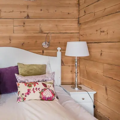 a bedroom with a bed with a lamp and pillows at Store Ringheim Hotel og Restaurant in Vossevangen