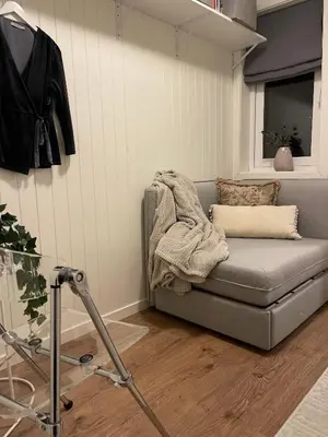 a couch in a living room with a blanket on a wall at Moderne hytte in Gjøvik