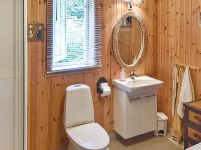 a bathroom with a toilet and a sink and a mirror at Seaside Serenity in Settem Fjord-By Traum in Bø
