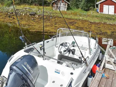 a white boat tied to a dock in the water at Seaside Serenity in Settem Fjord-By Traum in Bø