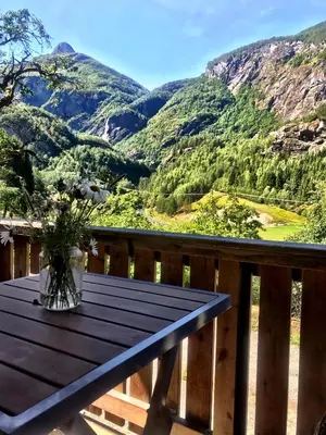 a table on a deck with a view of mountains at Gjørven Hytter in Flåm