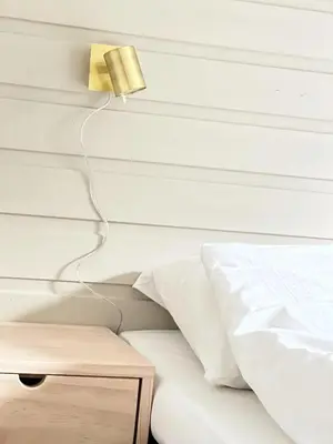 a bedroom with a bed and a lamp on the wall at Gjørven Hytter in Flåm