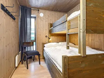 a bedroom with two bunk beds and a chair at 10 person holiday home in Fåvang in Favang
