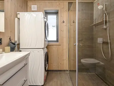 a white refrigerator in a bathroom with a shower at 10 person holiday home in Fåvang in Favang