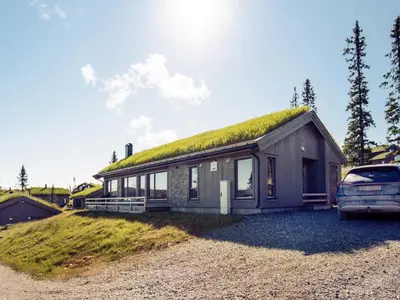 a house with a grass roof with a car parked in front at 10 person holiday home in Fåvang in Favang