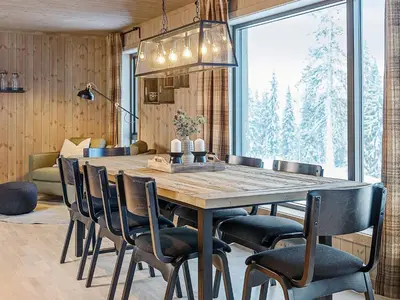 a dining room with a wooden table and chairs at 10 person holiday home in Fåvang in Favang