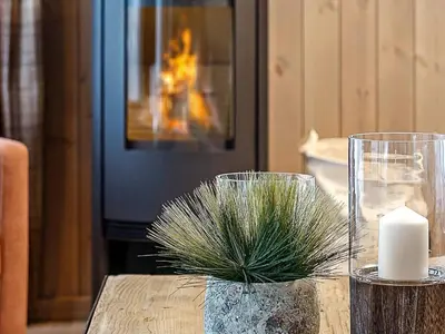 a table with two glass vases and a candle at 10 person holiday home in Fåvang in Favang