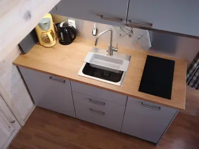 a kitchen counter with a sink and a microwave at Trollveggen Camping in Åndalsnes
