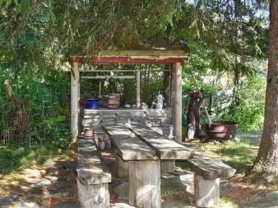 a wooden bench sitting under a tree in a park at Vintage Charm by the Sea-By Traum in Bø