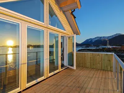 a house with a deck with a view of the water at 10 person holiday home in Brattvåg in Brattvåg