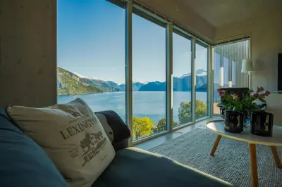 a living room with a large window view of the water at Fjord View Apartment in Stranda