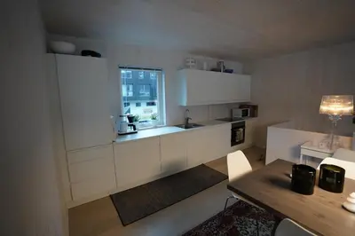 a kitchen with white cabinets and a window at Fjord View Apartment in Stranda