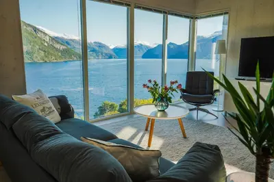 a living room with a large view of a lake at Fjord View Apartment in Stranda