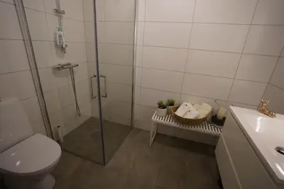 a bathroom with a shower and a toilet and a sink at Fjord View Apartment in Stranda