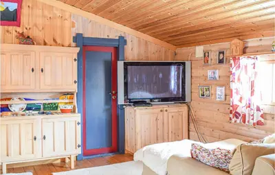 a living room with a flat screen tv in a cabin at Cozy Home In Rauland With Wifi in Rauland