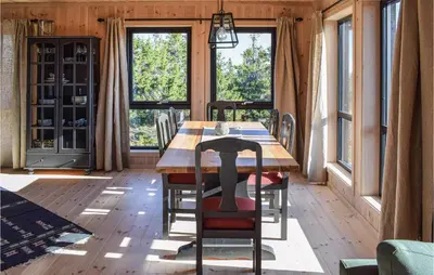 a dining room with a table and chairs and windows at 4 Bedroom Beautiful Home In Sjusjøen in Sjusjøen