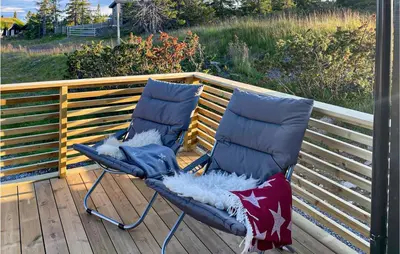 two chairs sitting on top of a deck at 4 Bedroom Beautiful Home In Sjusjøen in Sjusjøen