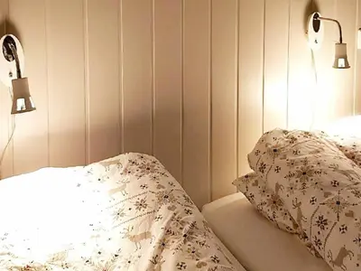 a bedroom with a bed with two lights on it at 10 person holiday home in Brattvåg in Brattvåg