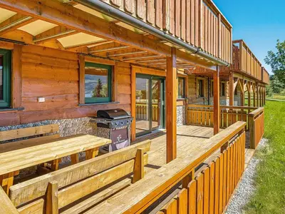 a wooden house with benches and a grill on it at 5 person holiday home in EIDSVÅG in Eidsvåg