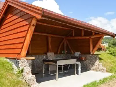 an outdoor grill with a table under a roof at 5 person holiday home in EIDSVÅG in Eidsvåg