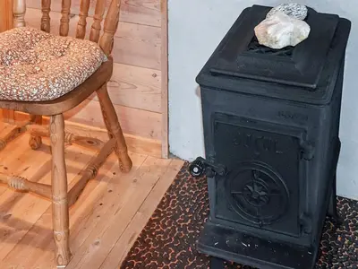 a black stove and a chair in a room at 4 person holiday home in Leirvik i Sogn in Leirvik