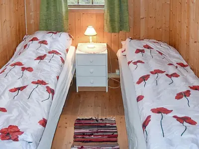 a bedroom with two beds and a night stand at 4 person holiday home in Leirvik i Sogn in Leirvik