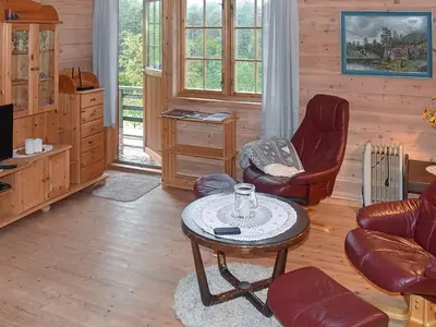a living room with a coffee table and chairs at 4 person holiday home in Leirvik i Sogn in Leirvik