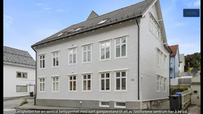 a large white building with a gambrel roof at Central apartment in walking distance from the city. in Ålesund
