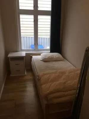 a small bedroom with a bed and a window at Central apartment in walking distance from the city. in Ålesund