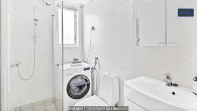 a white bathroom with a washing machine on the toilet at Central apartment in walking distance from the city. in Ålesund