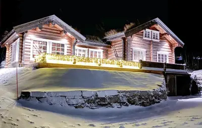 a house in the snow with lights on it at Pet Friendly Home In Hovden I Setesdal in Hovden