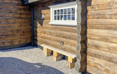 a wooden wall with a bench in front of a window at Pet Friendly Home In Hovden I Setesdal in Hovden