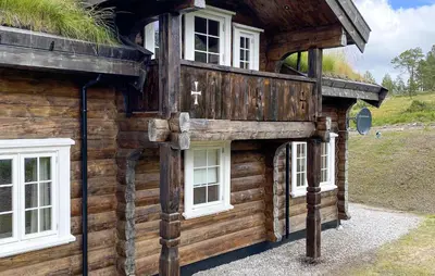 a wooden house with white windows on the side of it at Pet Friendly Home In Hovden I Setesdal in Hovden