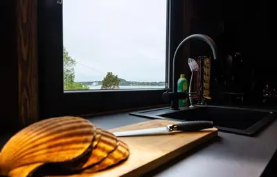 a wooden cutting board with a knife on a kitchen counter at Atlantic View Ingerstua in Frei