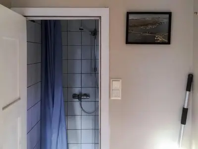 a bathroom with a shower with a blue shower curtain at 6 person holiday home in averøy-By Traum in Averoy