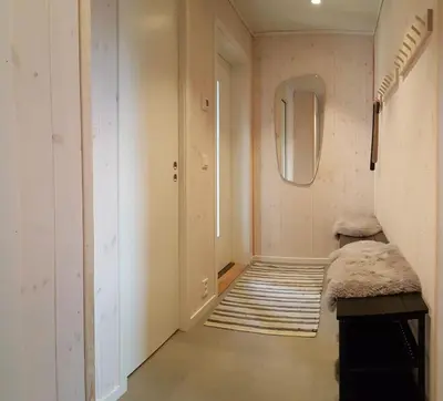 a hallway with a mirror and a rug at New and Exclusive Cottage in Voss with a great view in Skulestadmo