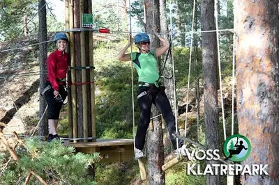 two people on a zip line in the trees at New and Exclusive Cottage in Voss with a great view in Skulestadmo
