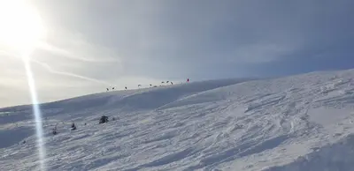 a group of people skiing down a snow covered slope at New and Exclusive Cottage in Voss with a great view in Skulestadmo