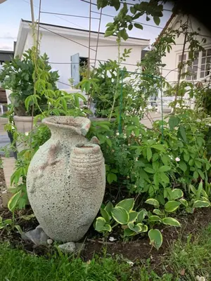 a large stone vase sitting next to some plants at The Gingerbread House in Lillehammer