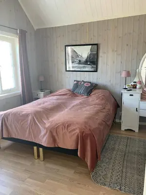 a bedroom with a bed and a table with two lamps at The Gingerbread House in Lillehammer