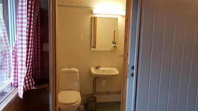 a small bathroom with a toilet and a sink at Leilighet 2240 in Haugsvær