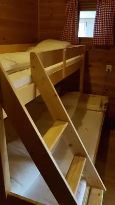 two bunk beds in a cabin with a window at Leilighet 2240 in Haugsvær
