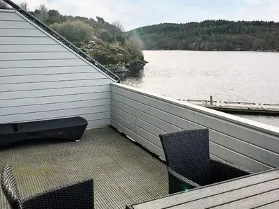 a balcony with two chairs and a view of a lake at 6 person holiday home in Seim in Seim