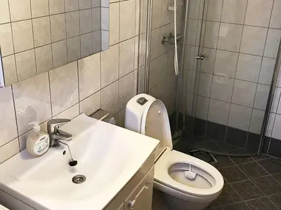 a bathroom with a sink and a toilet and a shower at 6 person holiday home in Seim in Seim