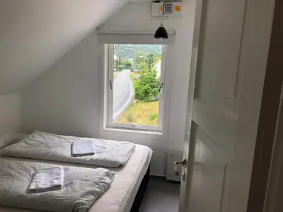 a small bedroom with a bed and a window at Vasstun Panorama in Odda