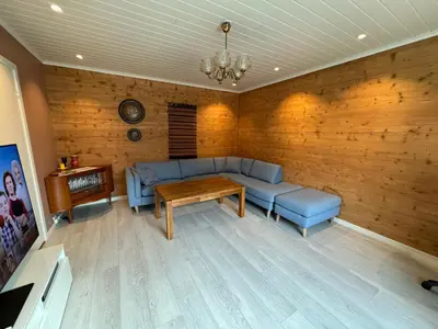 a living room with a blue couch and a table at Vasstun Panorama in Odda